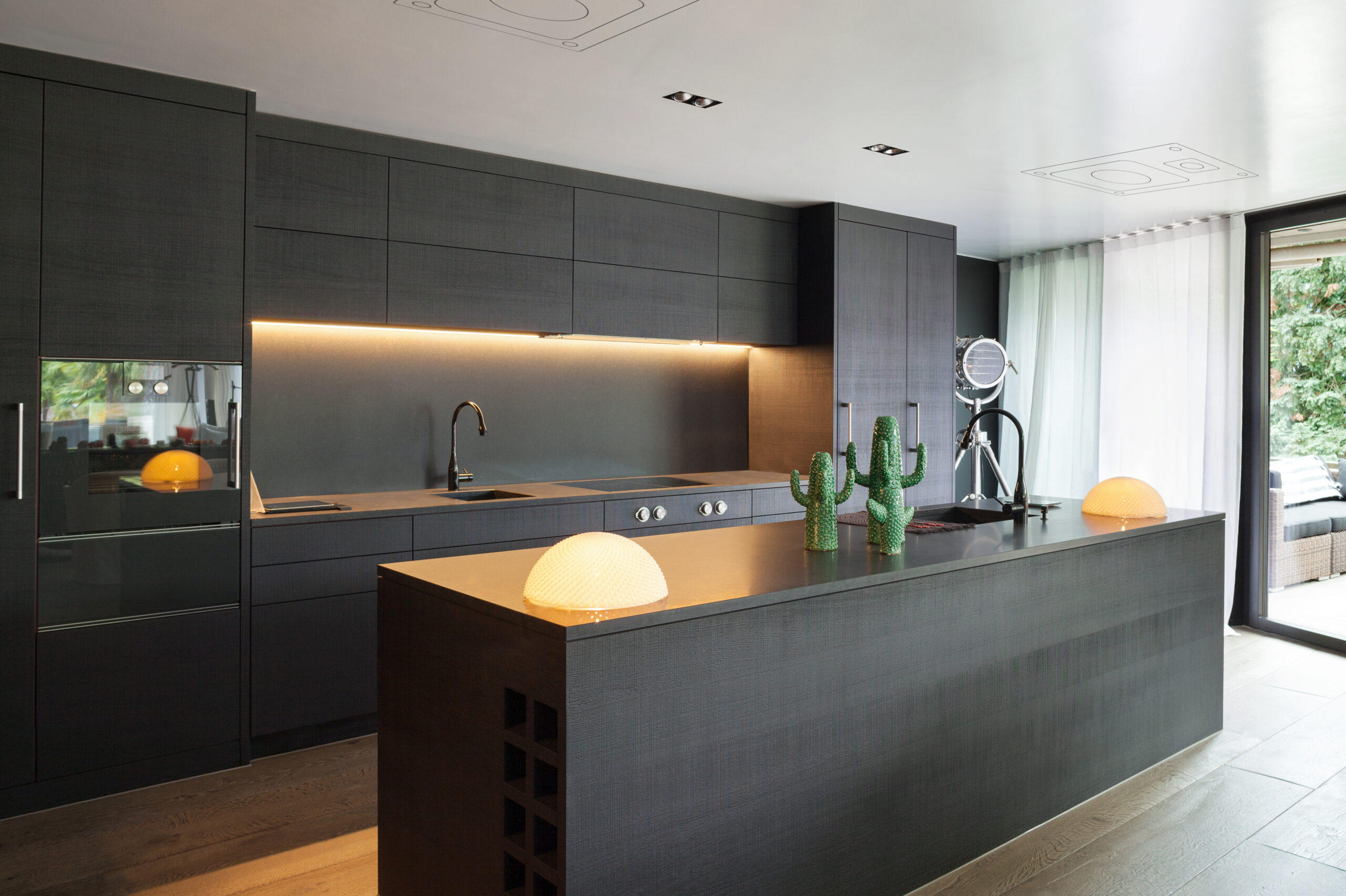 Modern kitchen with black furniture and wooden floor